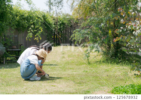 Girl sitting on the grass and playing 125678932