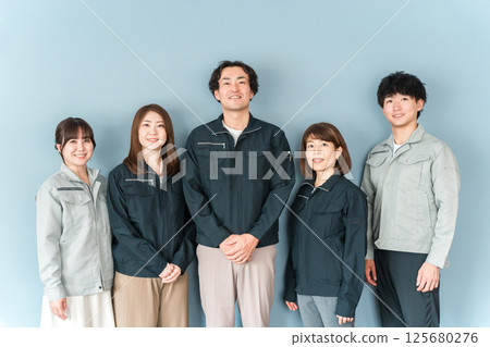 Employees and staff (businessmen and businesswomen) wearing work clothes working at small and medium-sized enterprises such as factories and construction companies. 125680276