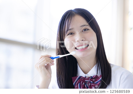 Dental care: High school girl brushing her teeth Dental care: High school girl brushing her teeth 125680589