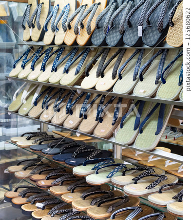 A variety of sandals and geta on display at a retro footwear store 125680622