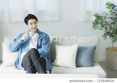 一個年輕人喝咖啡 125680626