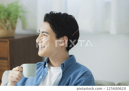 一個年輕人喝咖啡 125680628