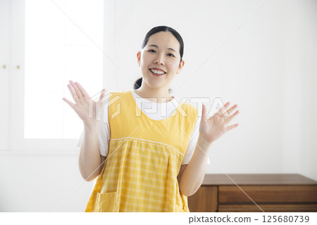 Middle-aged woman in a yellow apron 125680739