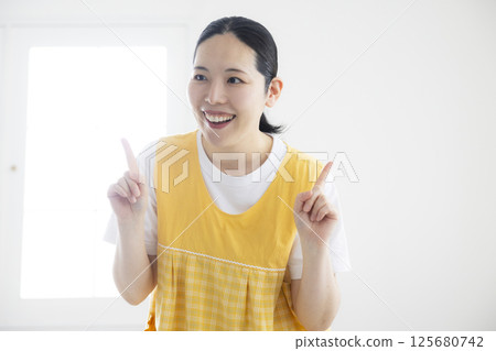 穿著黃色圍裙的中年婦女 穿著黃色圍裙的中年婦女 125680742