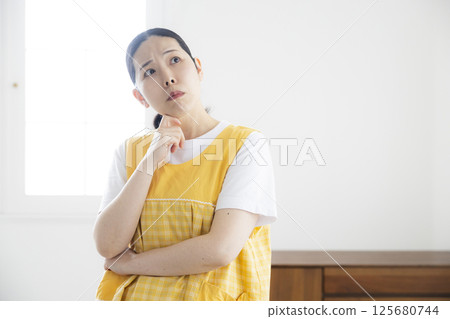 穿著黃色圍裙的中年婦女 穿著黃色圍裙的中年婦女 125680744