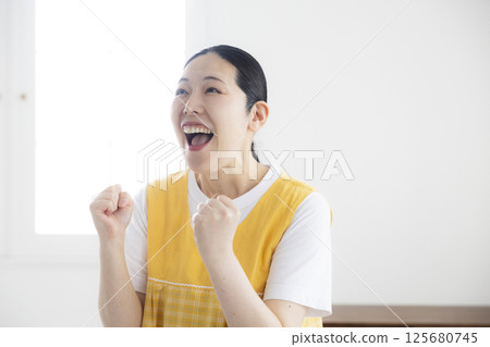 穿著黃色圍裙的中年婦女 125680745