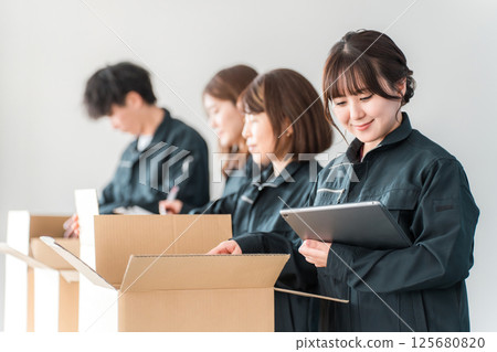 Male and female transportation, logistics, courier, distribution, delivery, and delivery workers packing items into cardboard boxes 125680820
