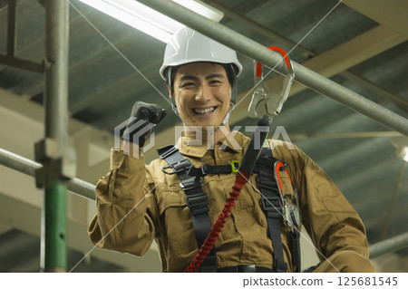 Male worker wearing a full harness 125681545