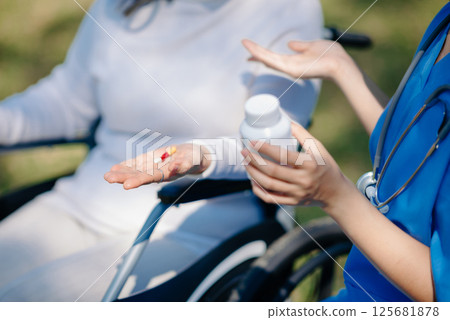 Elderly asian senior woman on wheelchair with Asian careful caregiver. Nursing home hospital garden 125681878