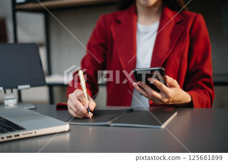 Businesswoman hand using laptop, tablet and smartphone in office. Digital marketing media mobile app and discussing plan new start up project. 125681899