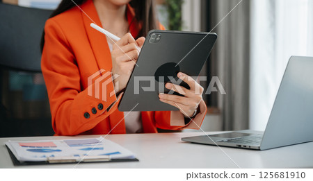 Businesswoman hand using laptop, tablet and smartphone. Digital marketing media mobile app and discussing plan new start up project. Finance task. 125681910