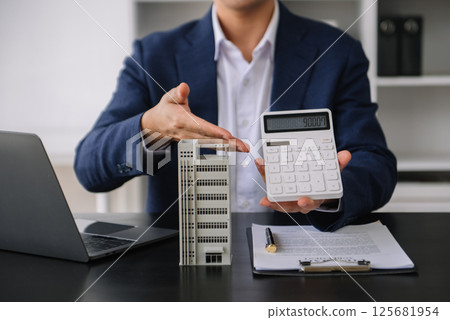 Real estate broker agent presenting to customer to decision making sign insurance form agreement, buy and sell home model, concerning mortgage loan offer 125681954