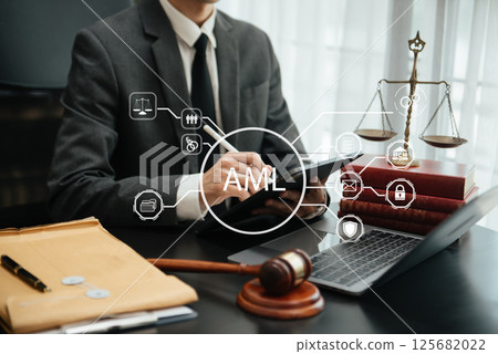 AML Anti Money Laundering Financial Bank Business Concept. judge in a courtroom using laptop and tablet with AML anti money laundering icon on virtual  screen. 125682022
