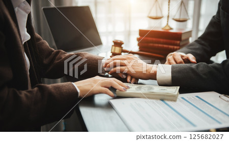 Judge gavel with scales of justice, Business and lawyer or counselor consulting and discussing contract papers with laptop and tablet at law firm 125682027