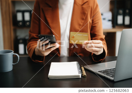businesswoman hand using smart phone, tablet payments and holding credit card online shopping, omni channel, digital tablet computer businesswoman hand using smart phone, tablet payments and holding credit card online shopping, omni channel, digital tablet computer 125682063