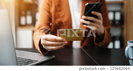 businesswoman hand using smart phone, tablet payments and holding credit card online shopping, omni channel, digital tablet computer businesswoman hand using smart phone, tablet payments and holding credit card online shopping, omni channel, digital tablet computer 125682064