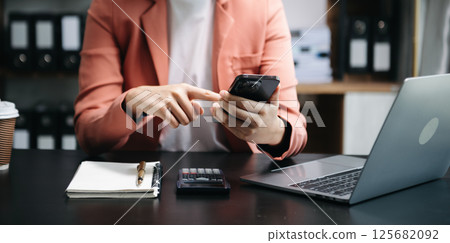 Businesswoman hand using laptop, tablet and smartphone in office. Digital marketing media mobile app and discussing plan new start up project. Finance task. 125682092