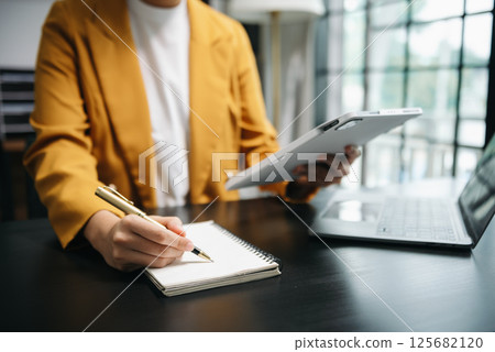businesswoman hand working with new modern computer and writing on the notepad strategy diagram as concept 125682120