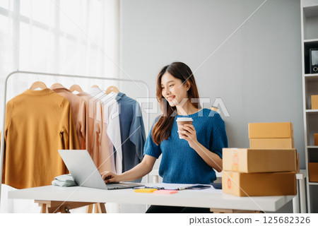 Startup small business SME, Entrepreneur owner woman using smartphone or tablet taking receive and checking online purchase shopping order 125682326