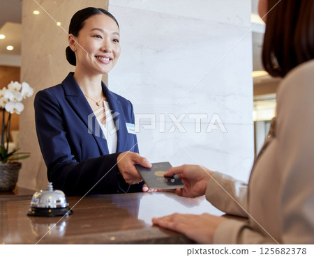 Female staff serving customers at the hotel front desk 125682378