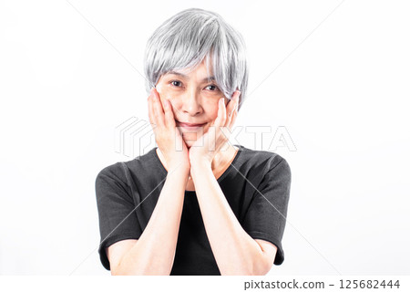 一位老年婦女用手托著下巴微笑 125682444