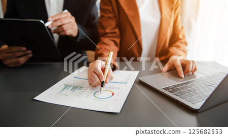 Business documents on office table with smart phone and calculator digital tablet and graph 125682553