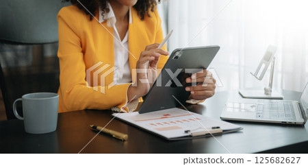 African businesswoman hand working with new modern computer using on smartphone and tablet as concept African businesswoman hand working with new modern computer using on smartphone and tablet as concept 125682627