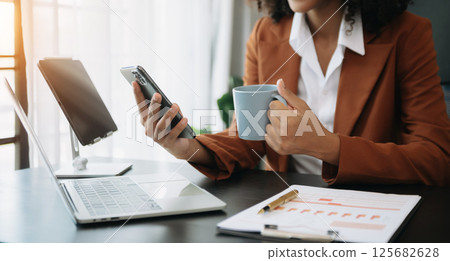 African businesswoman hand working with new modern computer using on smartphone and tablet as concept 125682628