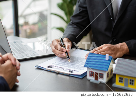 Considering buying a home, investing in real estate. Broker signs a sales agreement. agent, lease agreement, successful deal Considering buying a home, investing in real estate. Broker signs a sales agreement. agent, lease agreement, successful deal 125682653