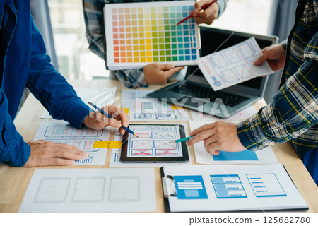 UX developer and ui designer brainstorming about mobile app interface wireframe design with customer breif and color code at modern office. UX developer and ui designer brainstorming about mobile app interface wireframe design with customer breif and color code at modern office. 125682780
