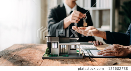 Signing a contract. Client and broker agent, lease agreement, successful deal and Young business sitting at the desk in office Signing a contract. Client and broker agent, lease agreement, successful deal and Young business sitting at the desk in office 125682788