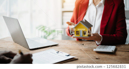 Signing a contract. Client and broker agent, lease agreement, successful deal and Young business sitting at the desk in office Signing a contract. Client and broker agent, lease agreement, successful deal and Young business sitting at the desk in office 125682831