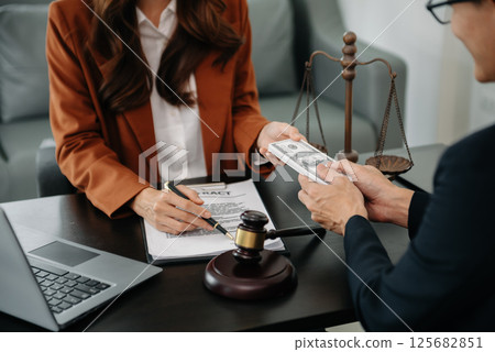 justice and law concept.passing bribe money in the envelop at lawyer office. businessman hand taking bribe money from female justice and law concept.passing bribe money in the envelop at lawyer office. businessman hand taking bribe money from female 125682851