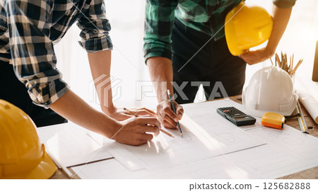 Two colleagues discussing data working and tablet, laptop with on on architectural project at construction site 125682888