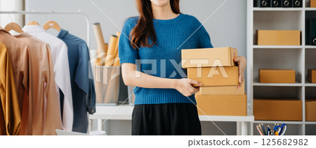 Young woman running online store Startup small business SME, using smartphone or tablet taking receive and checking online purchase shopping Young woman running online store Startup small business SME, using smartphone or tablet taking receive and checking online purchase shopping 125682982