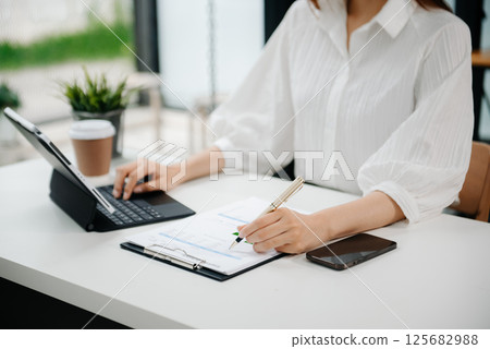 Woman hand using laptop, tablet and smartphone in office. Digital marketing media mobile app and discussing plan new start up project. Finance task. Woman hand using laptop, tablet and smartphone in office. Digital marketing media mobile app and discussing plan new start up project. Finance task. 125682988