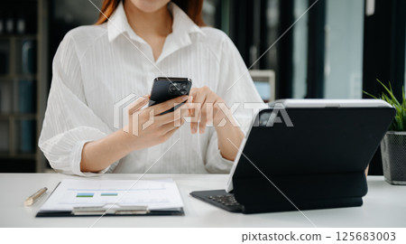 Woman hand using laptop, tablet and smartphone in office. Digital marketing media mobile app and discussing plan new start up project. Finance task. 125683003