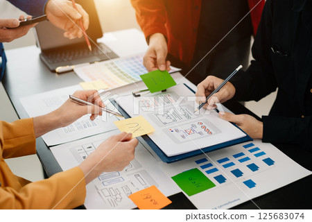UX developer and ui designer brainstorming about mobile app interface wireframe design with customer breif and color code at modern office. UX developer and ui designer brainstorming about mobile app interface wireframe design with customer breif and color code at modern office. 125683074