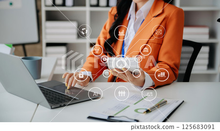 Businesswoman working with smart phone and laptop and digital tablet computer in office with digital marketing media in virtual icon 125683091