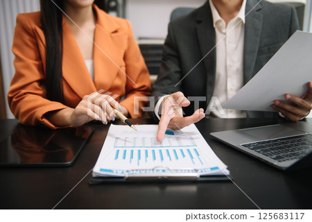 Businessman and team analyzing financial statement Finance task. with smart phone and laptop and  tablet. Wealth management concept 125683117