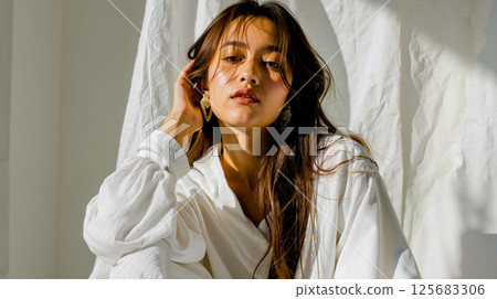 A woman in a white shirt is posing for a picture 125683306