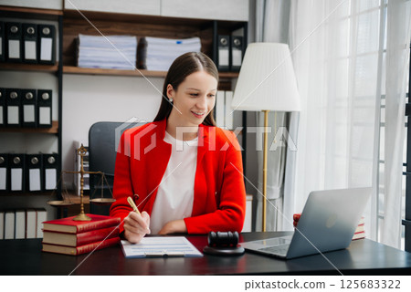 justice and law concept.Female judge in a courtroom on wooden table and Counselor or Female lawyer working in office. justice and law concept.Female judge in a courtroom on wooden table and Counselor or Female lawyer working in office. 125683322