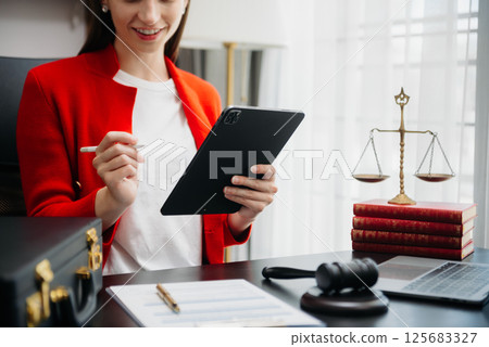 justice and law concept.Male judge in a courtroom the gavel, working with smart phone and laptop and digital tablet computer on table justice and law concept.Male judge in a courtroom the gavel, working with smart phone and laptop and digital tablet computer on table 125683327