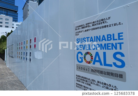 Flat panel temporary fencing at a construction site displays information about SDGs initiatives Flat panel temporary fencing at a construction site displays information about SDGs initiatives 125683378