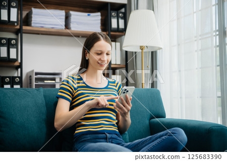 Caucasian businesswoman working in the office with working notepad, tablet and laptop documents on sofa in home office Caucasian businesswoman working in the office with working notepad, tablet and laptop documents on sofa in home office 125683390