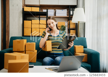 Small business entrepreneur SME freelance woman working at home office, BOX,tablet and laptop online, marketing, packaging, delivery 125683433