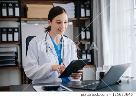 Medical technology concept. Doctor working with mobile phone and stethoscope and digital tablet laptop in modern office at hospital 125683646