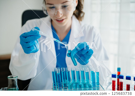 Modern medical research laboratory. female scientist working with micro pipettes analyzing biochemical samples, advanced science chemical laboratory for medicine. Modern medical research laboratory. female scientist working with micro pipettes analyzing biochemical samples, advanced science chemical laboratory for medicine. 125683738