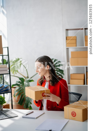 Startup small business SME, Entrepreneur owner woman using smartphone or tablet taking receive and checking online purchase shopping order 125683935