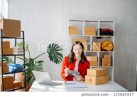 Startup small business SME, Entrepreneur owner woman using smartphone or tablet taking receive and checking online purchase shopping order 125683937